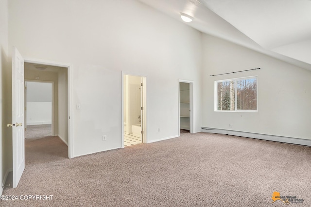 unfurnished bedroom with ensuite bath, light colored carpet, high vaulted ceiling, and a baseboard radiator