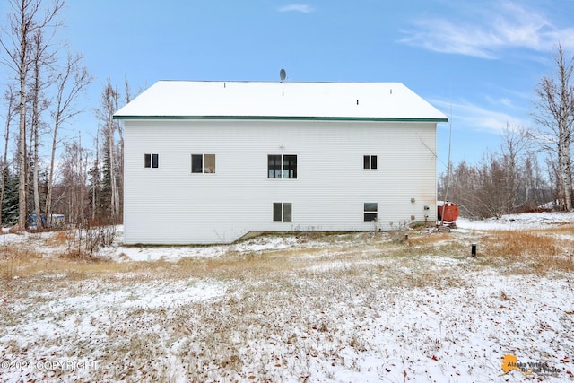 view of snow covered back of property