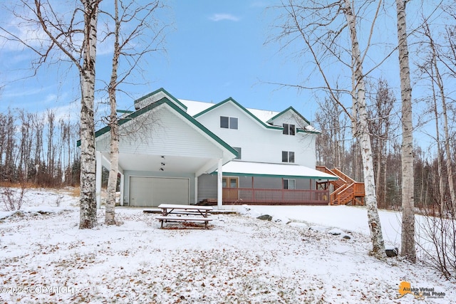 snow covered house featuring a wooden deck