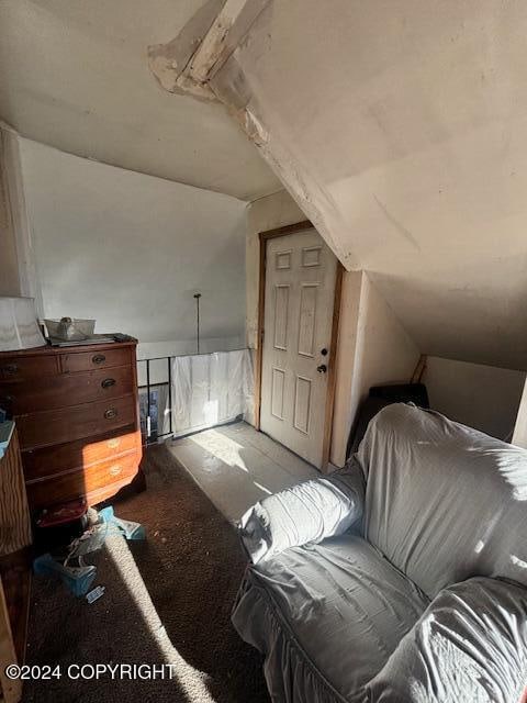 bedroom featuring lofted ceiling and light colored carpet