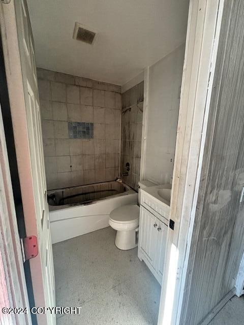 full bathroom featuring tiled shower / bath, vanity, and toilet