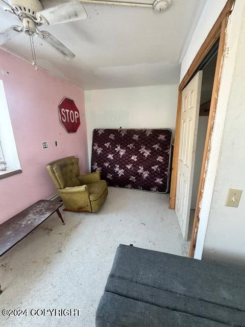 sitting room with concrete floors and ceiling fan