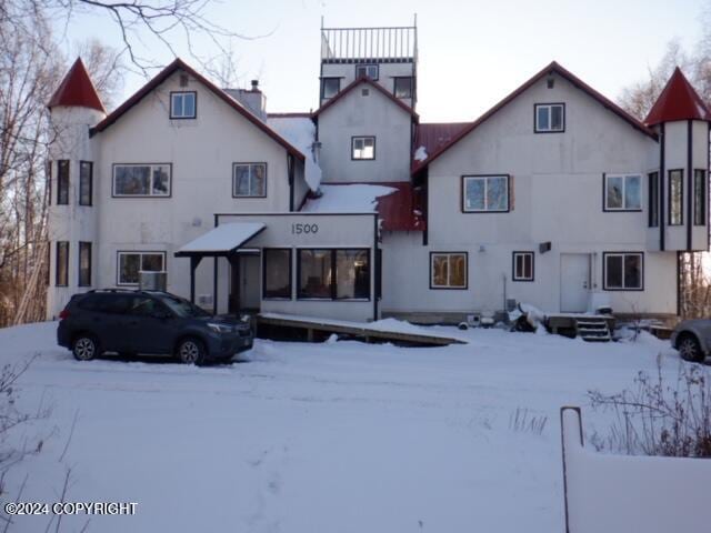 view of snow covered back of property