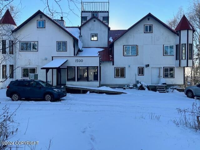 view of snow covered rear of property