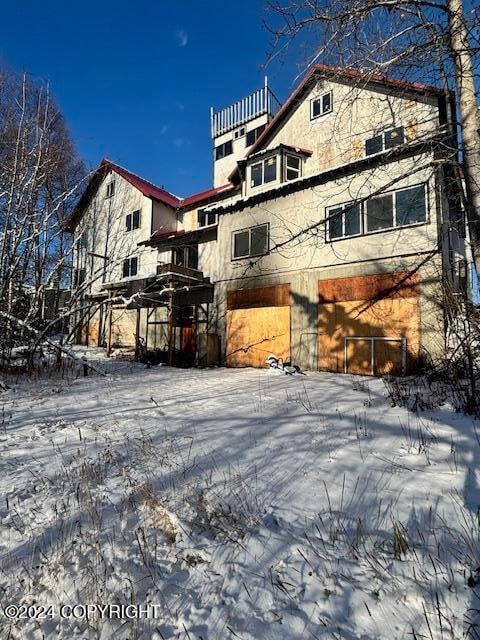 view of snow covered rear of property