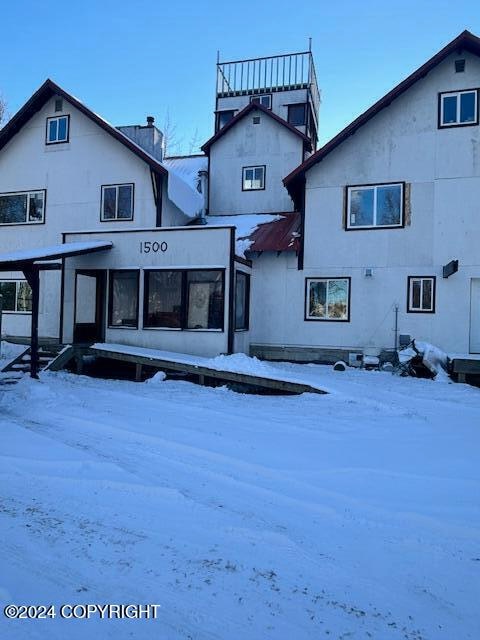 view of snow covered rear of property