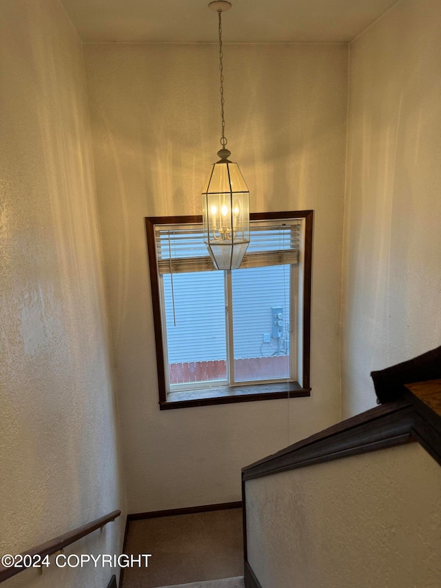 staircase featuring an inviting chandelier