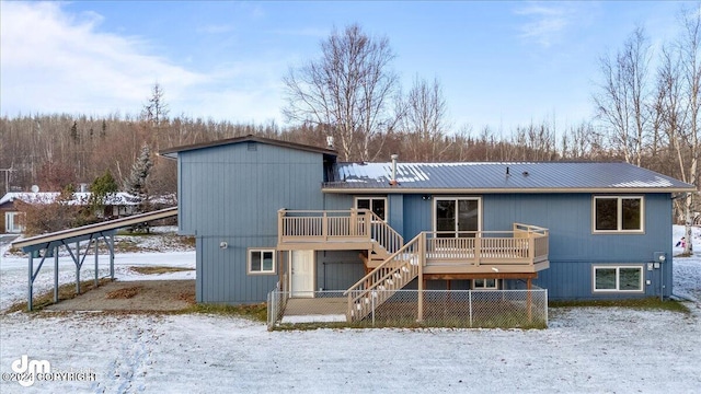 snow covered house with a wooden deck