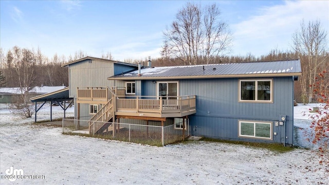 snow covered rear of property with a wooden deck