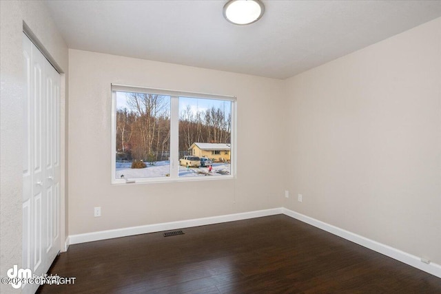 spare room with dark hardwood / wood-style flooring