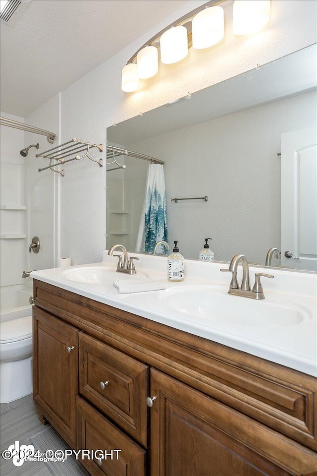 full bathroom with toilet, vanity, and shower / tub combo