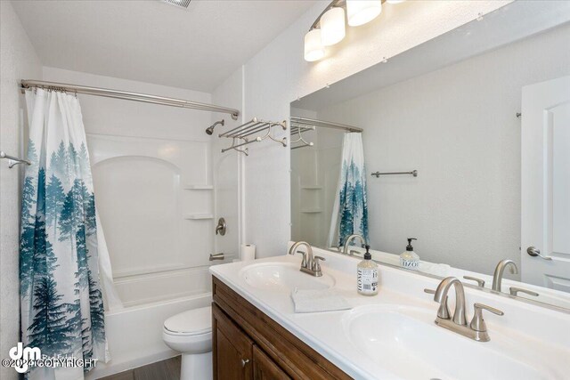 full bathroom with toilet, shower / bathtub combination with curtain, and vanity