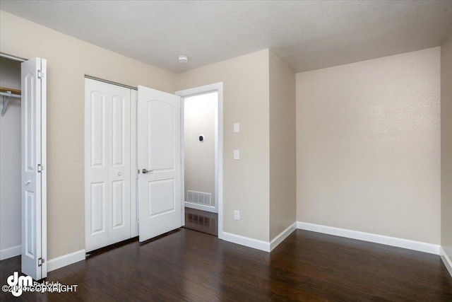 unfurnished bedroom featuring dark hardwood / wood-style floors