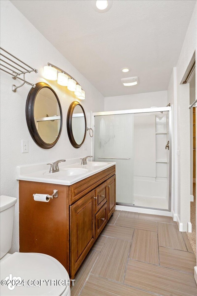 bathroom with toilet, walk in shower, and vanity