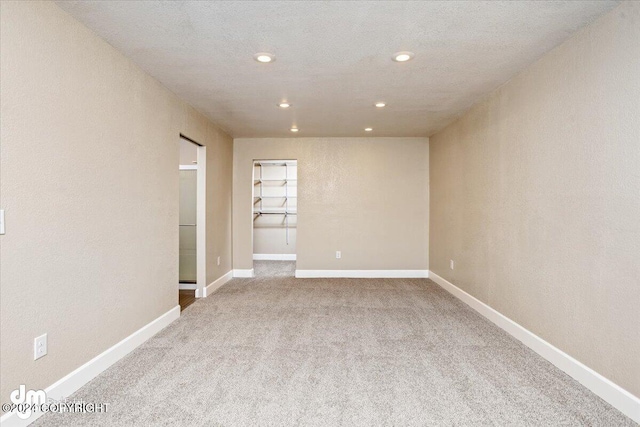 carpeted spare room with a textured ceiling