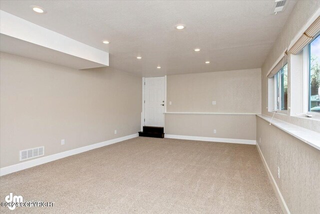 carpeted empty room featuring a textured ceiling