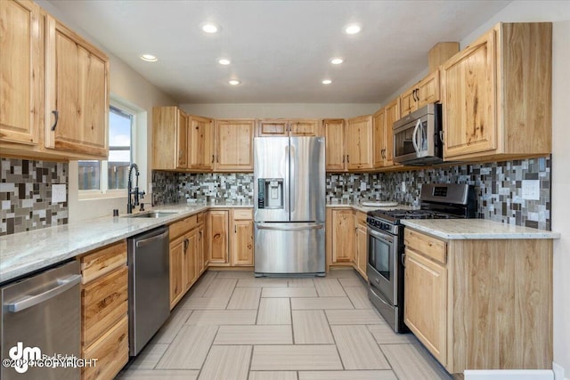 kitchen featuring appliances with stainless steel finishes, light stone countertops, sink, and light brown cabinetry