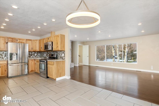 kitchen with appliances with stainless steel finishes, tasteful backsplash, hanging light fixtures, and light wood-type flooring