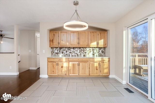 bar with backsplash, ceiling fan, decorative light fixtures, light hardwood / wood-style flooring, and light brown cabinets