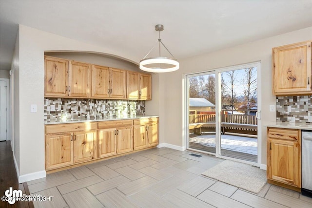 kitchen with stainless steel dishwasher, decorative backsplash, hanging light fixtures, and light brown cabinetry