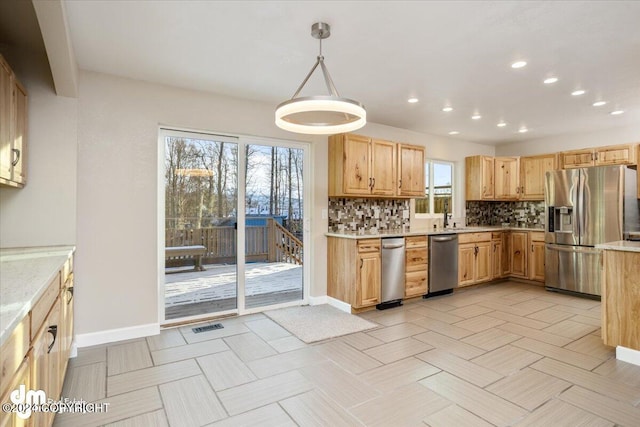 kitchen with stainless steel appliances, tasteful backsplash, plenty of natural light, and hanging light fixtures