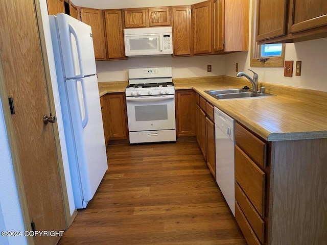 kitchen with white appliances, sink, and dark hardwood / wood-style floors