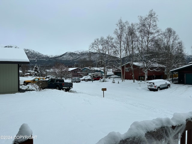 yard covered in snow featuring a mountain view