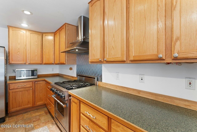 kitchen with appliances with stainless steel finishes and wall chimney range hood