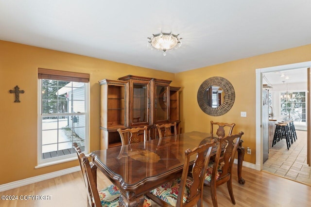 dining area featuring light hardwood / wood-style floors and a notable chandelier