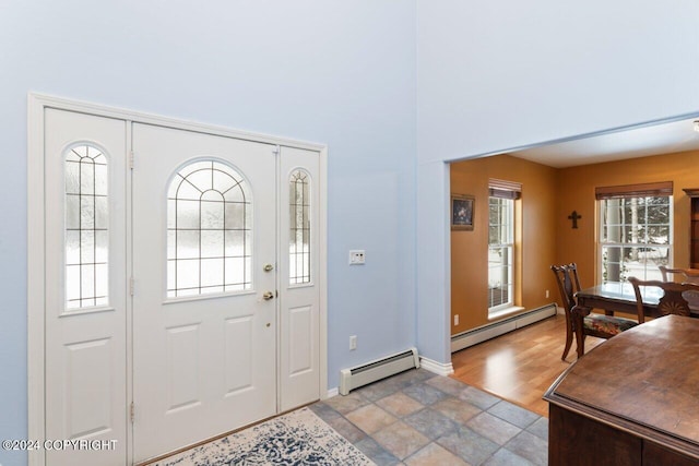 foyer entrance with baseboard heating and light hardwood / wood-style floors