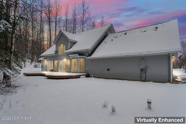 snow covered house with a deck