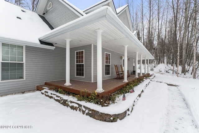 snow covered property with a porch