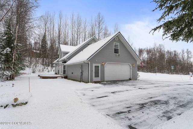 view of snowy exterior featuring a garage