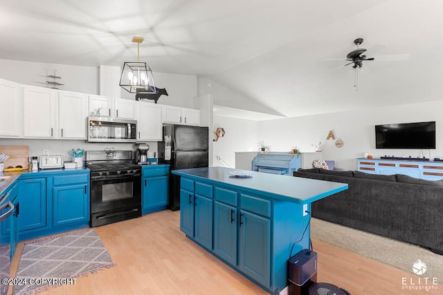 kitchen featuring vaulted ceiling, blue cabinets, white cabinets, black appliances, and decorative light fixtures