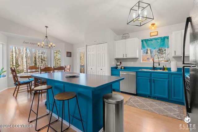 kitchen with a breakfast bar, stainless steel dishwasher, a kitchen island, blue cabinets, and pendant lighting