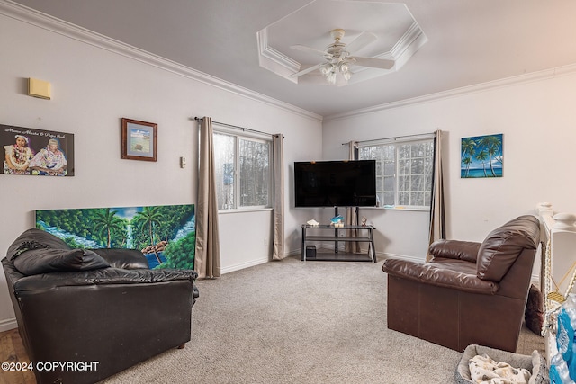 living room featuring ornamental molding, carpet flooring, ceiling fan, and a tray ceiling