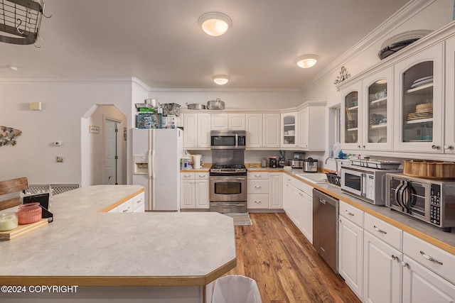 kitchen featuring crown molding, stainless steel appliances, sink, white cabinets, and light hardwood / wood-style flooring