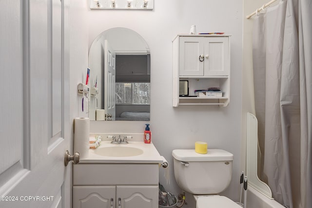 bathroom with walk in shower, vanity, and toilet