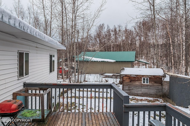 snow covered deck featuring a shed