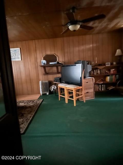 playroom with carpet flooring, radiator, ceiling fan, wooden walls, and wood ceiling