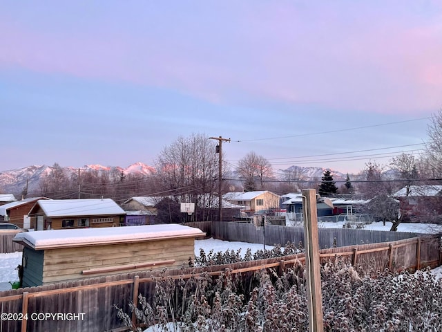 yard covered in snow with a mountain view