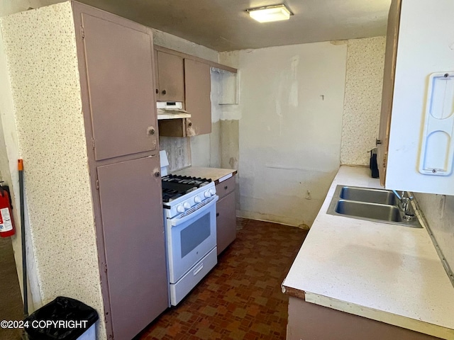 kitchen with white gas stove and sink