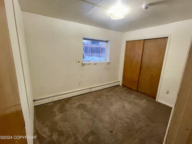 4312 E 6th Ave, Anchorage, AK 99508 - unfurnished bedroom with a baseboard heating unit, carpet floors, and a closet