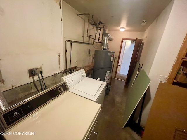 clothes washing area featuring water heater and washer and clothes dryer