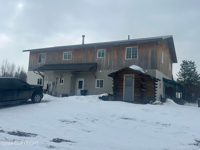 view of snow covered rear of property