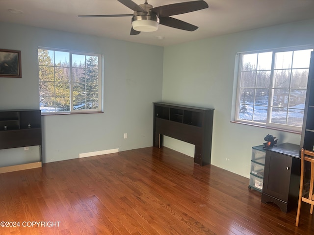 living room with dark wood-type flooring and ceiling fan