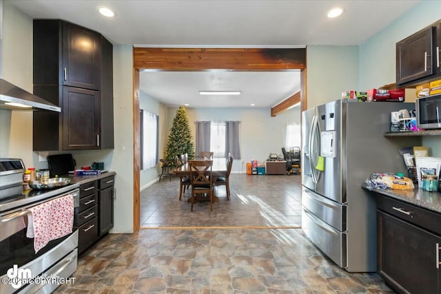 kitchen featuring stainless steel appliances, dark brown cabinetry, beam ceiling, dark stone countertops, and wall chimney range hood