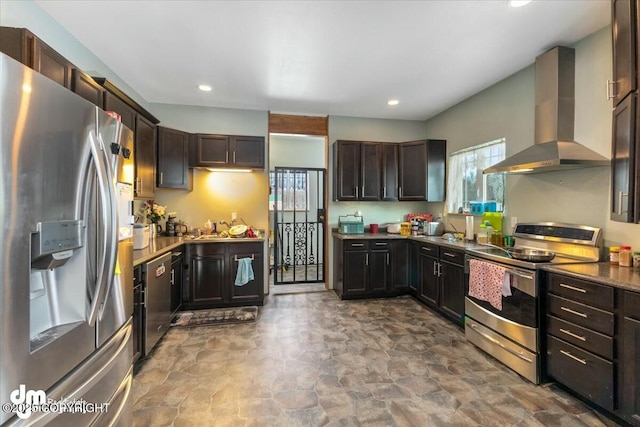 kitchen with appliances with stainless steel finishes, dark brown cabinetry, and wall chimney range hood