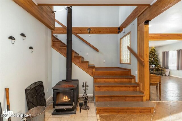 staircase with tile patterned flooring and a wood stove