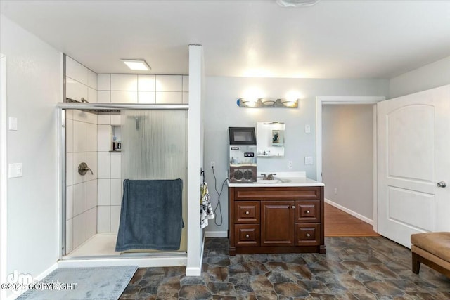 bathroom with a shower with shower door and vanity